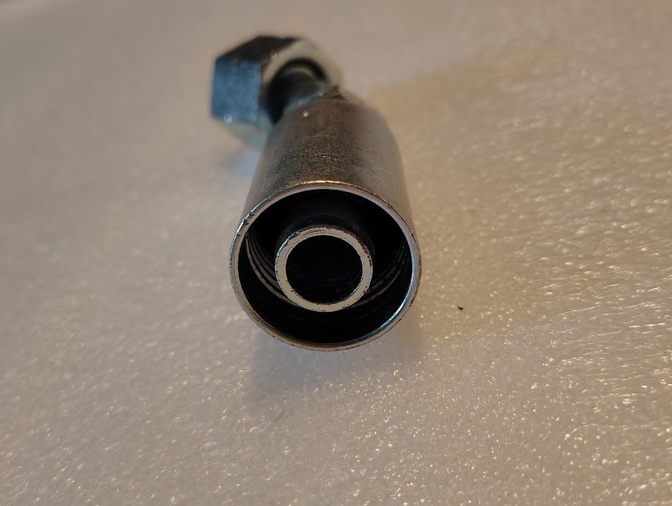 Close-up of a Weatherhead 5/8 Hose x 5/8 ORF Female Fitting - 45 Swivel (10U-L70) on a textured white surface, showing its interior threading with the open end facing the camera.