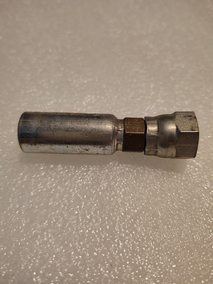 A slightly worn Weatherhead 04U-58C fitting, featuring a hexagonal nut and cylindrical body, rests on a textured white surface. Designed for 1/4 hoses or M16x1.5 DIN female connections, it hints at past use with machinery or equipment.