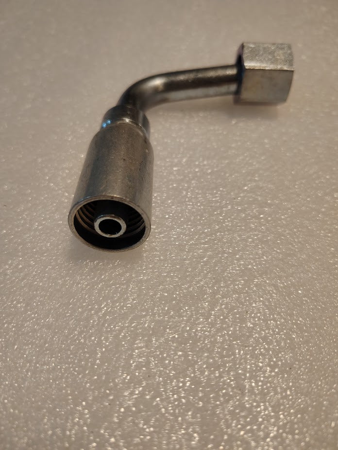 The 06U-A68 Weatherhead fitting, shown on a textured light surface, is a metal 3/8 hose x 1/2 ORF female hydraulic fitting with a 90-degree bend, hexagonal nut, and threaded opening for compatible hoses.