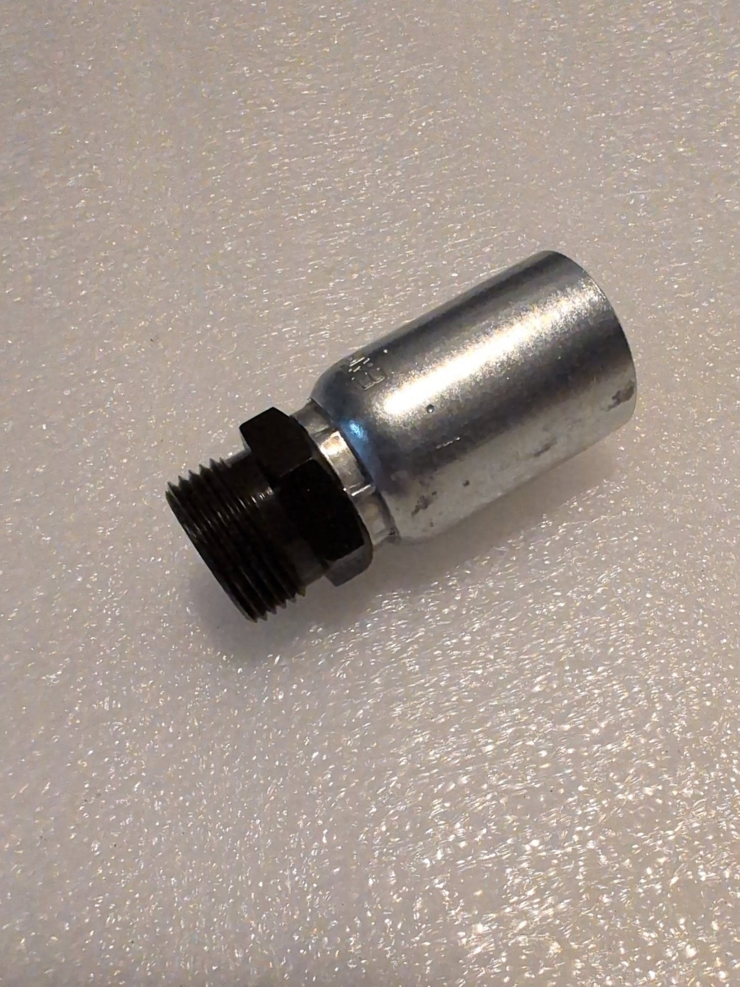 A Weatherhead 08U-15A 1/2 hose x M22x1.5 DIN male fitting (CS66-8X15) with a threaded black end and smooth silver cylindrical body is shown on a textured white surface.