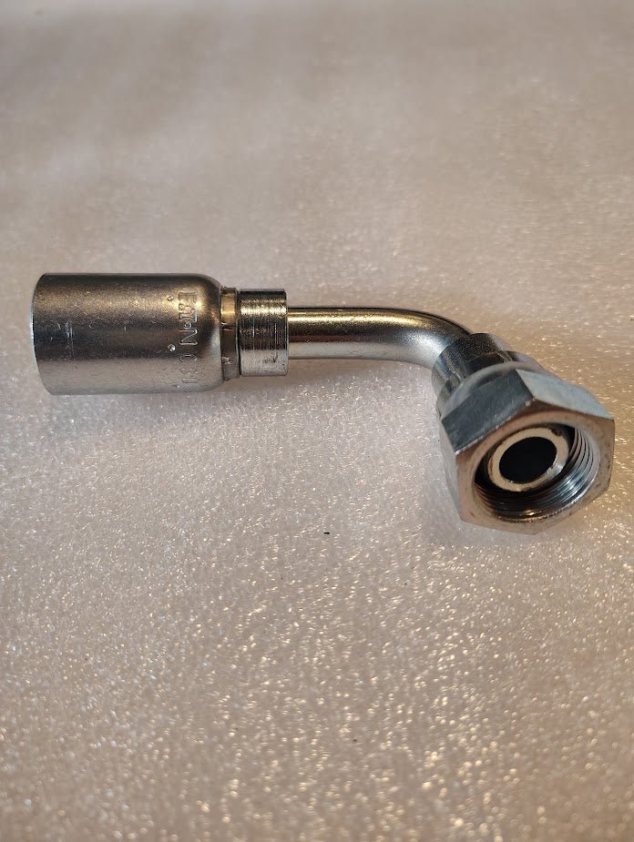 The 08U-65D | Weatherhead 1/2 Hose x M22x1.5 DIN Female Fitting (CS44-8X15), a metal hydraulic fitting with a 90° bend and hex nut for 100R16 hoses, is shown on a light textured surface.