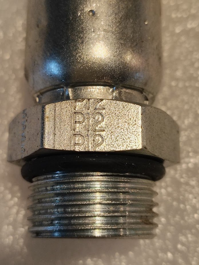 Close-up of a Weatherhead 10U-P12 (5/8 Hose x 3/4 ORB Male, CS11-10X12) metallic fitting with P2 and B12 marked on the hex nut, commonly used for hydraulic 100R1 hoses, shown on a textured white surface.