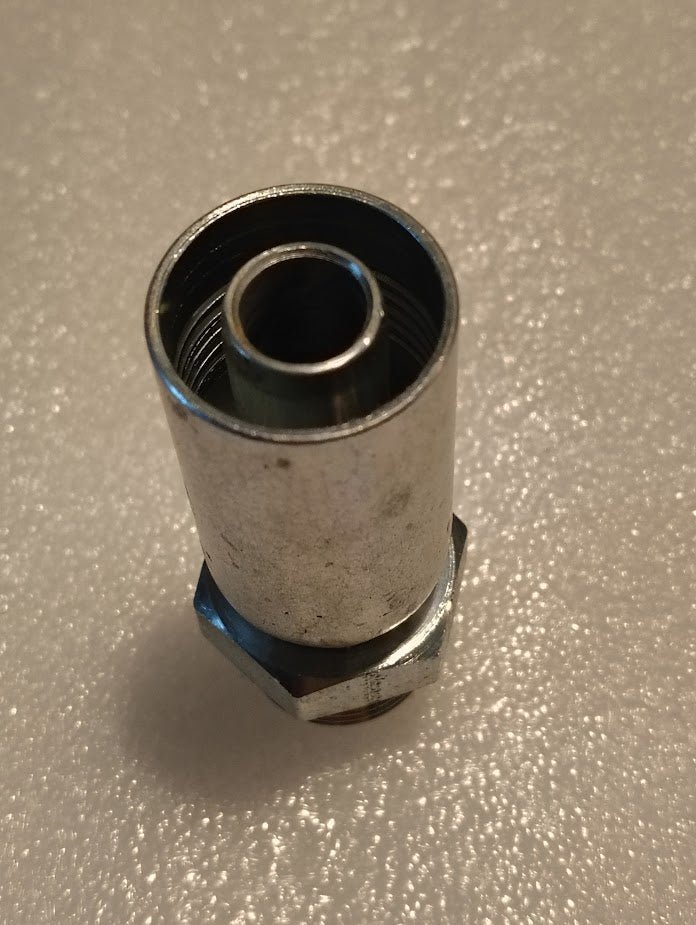 The 10U-P12 Weatherhead 5/8 Hose x 3/4 ORB Male Fitting (CS11-10X12) is a metal hex nut fitting with internal threading, shown upright on a textured white surface. Suitable for use with hydraulic hose fittings.
