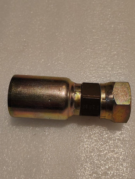 The 16U-33K Weatherhead fitting, a straight swivel hydraulic component with a 1 hose x M33x1.5 Komatsu female end, sits on a textured white surface, showcasing its mix of shiny and matte metallic finishes.
