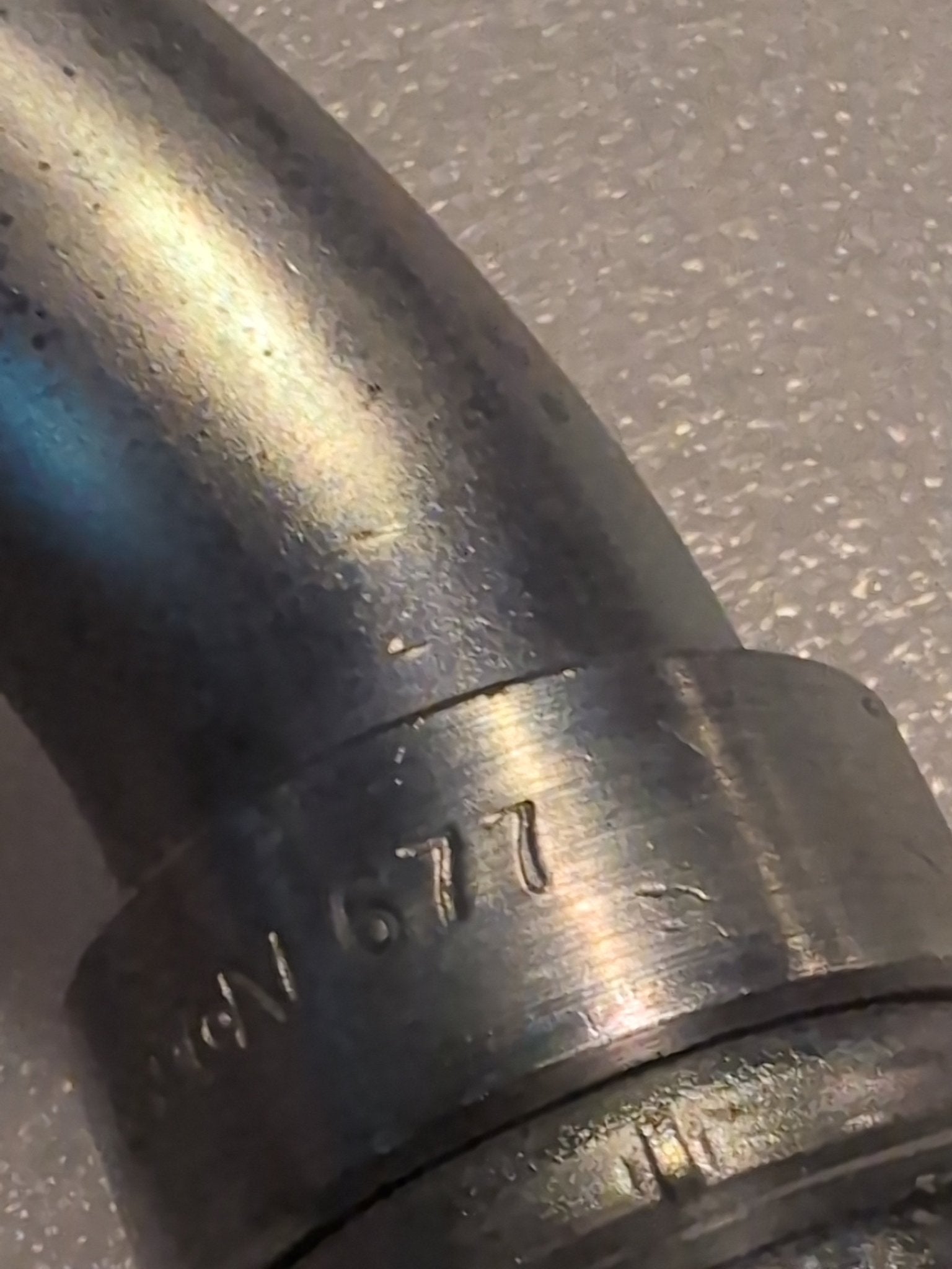 A close-up of the Weatherhead 20U-677 (1 1/4 hose x 1 1/4 JIC female fitting, CS26-20X20) metallic joint with 677 engraved shows its hydraulic hose compatibility on a textured gray background.