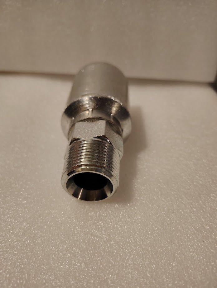 A close-up view of a Weatherhead 43012U-112 3/4 Hose x 3/4 NPTF male pipe fitting (GW01-12x12) with threaded ends, placed on a white textured surface.