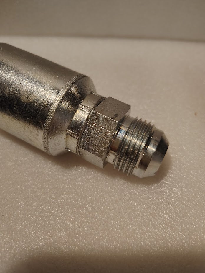 Close-up of a Weatherhead 43012U-512 (GW08-12x12) 3/4 hose x 3/4 JIC male hydraulic fitting with hexagonal nut and threaded end, Couplamatic compatible, on a textured off-white surface.