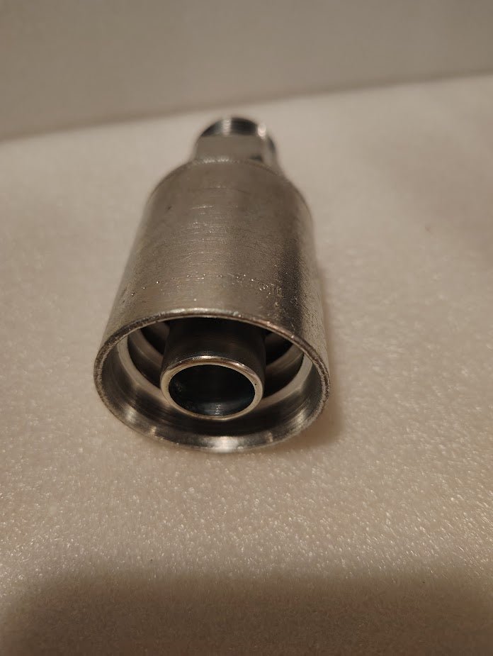 A close-up of the Weatherhead 43012U-512, a 3/4 hose x 3/4 JIC male fitting (GW08-12x12), on a textured white surface, displays its open end and internal components typical of hydraulic hose fittings.