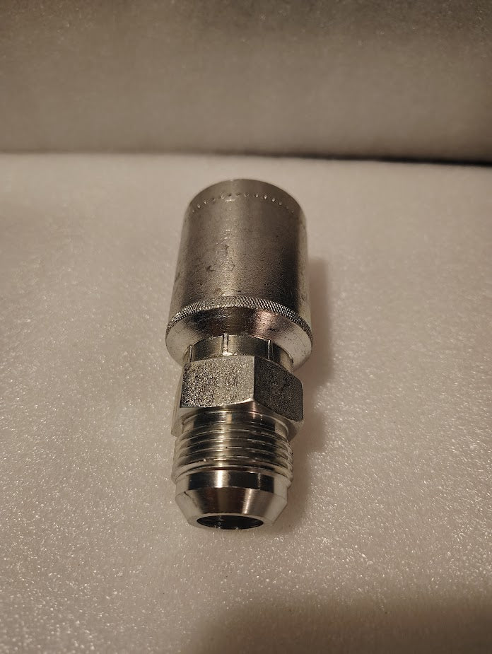 A 43012U-514 | 3/4 Hose x 7/8 JIC Solid Fitting - Straight (GW08-12x14) with a hex nut and threaded end, made of stainless steel, is shown resting on a textured white surface.