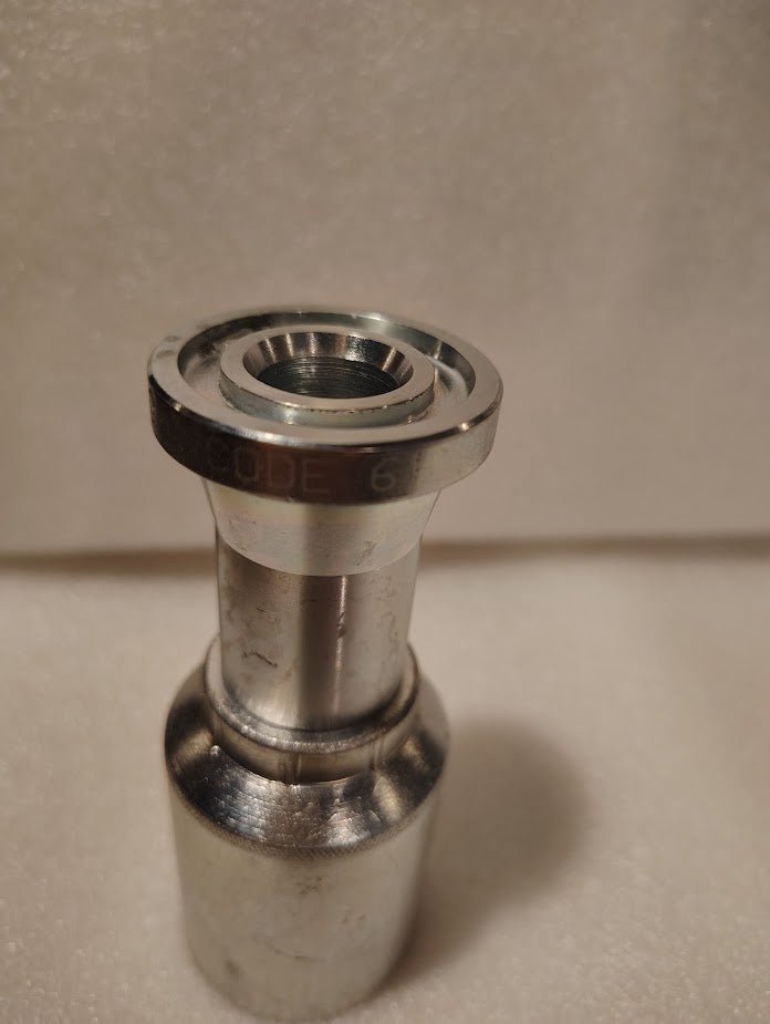 A close-up of the 43012U-G12 Weatherhead 3/4 Hose x 3/4 Code 61 Flange Fitting (GW47-12x12), a metallic cylindrical component with CODE 6A engraving, suitable for compatible hose fittings.