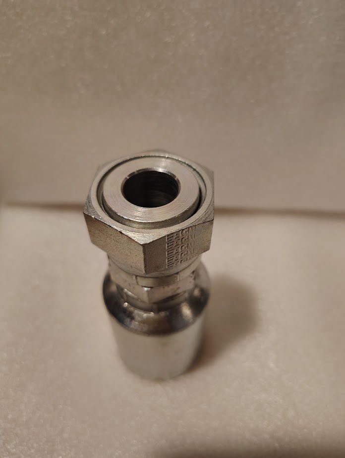 A close-up of a shiny 43012U-S72 Weatherhead 3/4 Hose x 3/4 ORFS Female Fitting (GW30-12x12), featuring a threaded opening, placed upright on a light textured surface.