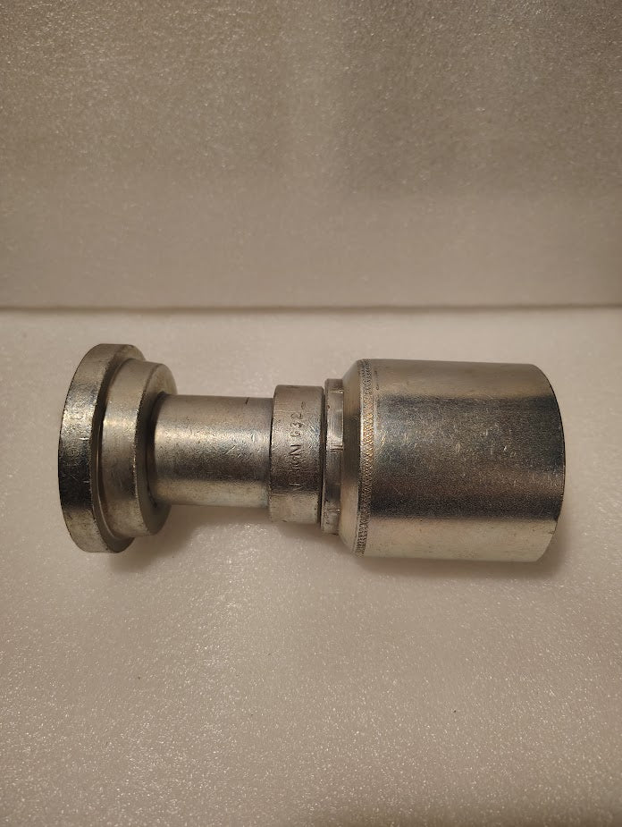The 43024U-G32 | 1 1/2 Hose x 2 Code 61 Flange Fitting – Straight (GW47-24x32) has a wide flat flange on one end and a contoured body, shown resting on a textured white surface.