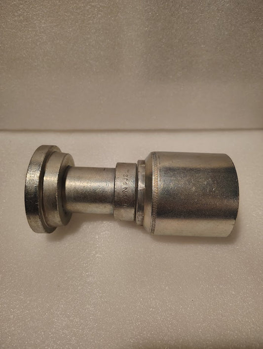 The 43024U-G32 | 1 1/2 Hose x 2 Code 61 Flange Fitting – Straight (GW47-24x32) has a wide flat flange on one end and a contoured body, shown resting on a textured white surface.