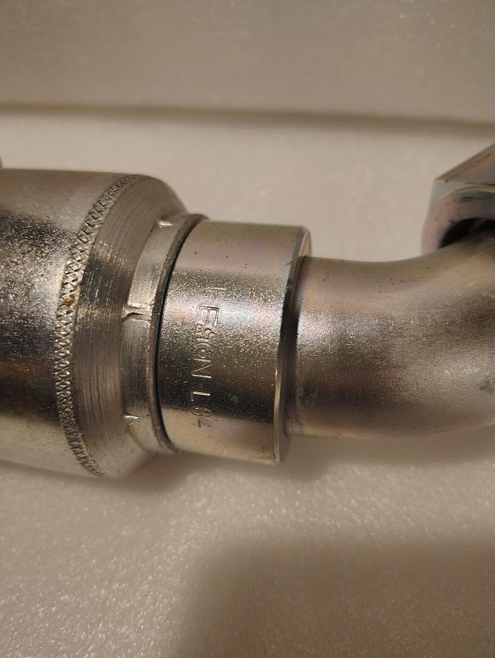 Close-up of the 43024U-L84 | 1 1/2 Hose x 1 1/2 ORFS Swivel Fitting with a 45° bend, model GW31-24x24—ideal for hydraulic applications needing reliable ORFS swivel connections.