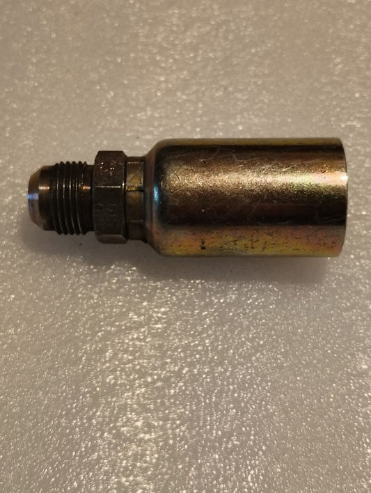 A 12U-510 Weatherhead fitting, a metallic cylindrical nozzle with a threaded end, lies on a textured surface. Its shiny, reflective finish showcases subtle color variations.