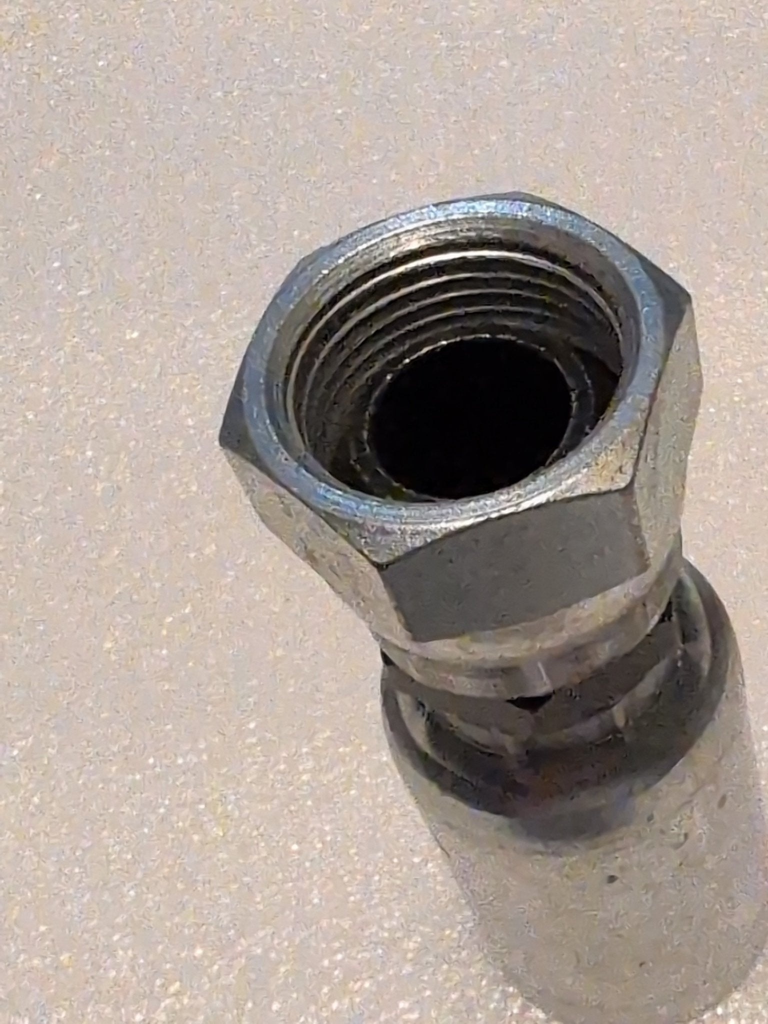 A 12U-362 Weatherhead connector, a metallic 3/4 Hose x 3/4 BSPP Female Fitting with a hex nut, is angled on a light-textured surface. The shiny swivel connector shows visible internal threading, ideal for hydraulic hose applications.