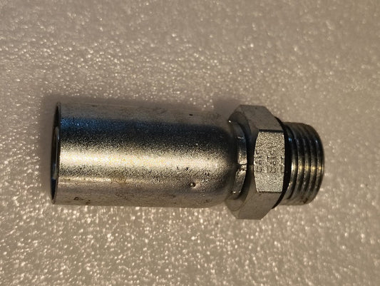The 10U-P12, a Weatherhead 5/8 Hose x 3/4 ORB Male Fitting with a straight solid design, shines slightly while resting on a textured white surface. The cylindrical body with its hexagonal nut displays minor wear marks.