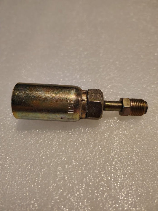 A metallic connector, the Weatherhead 06U-B04 3/8 Hose x 1/4 Inverted Male Fitting - Straight Swivel, with a cylindrical body and threaded ends rests on a textured white surface, featuring a shiny, slightly worn finish and a hexagonal section for tightening.