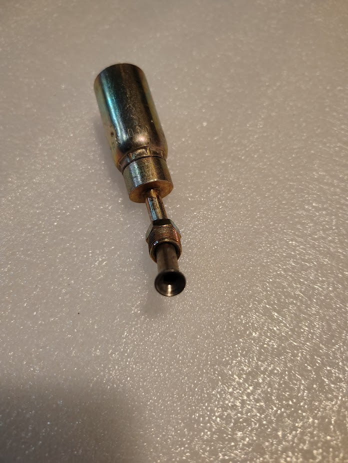 A close-up of the Weatherhead 06U-B44, a shiny metal tool for hydraulic hose fittings, with a cylindrical handle and narrow tip on a textured white surface.