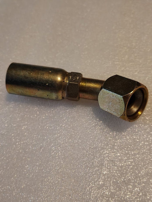 A 10U-692 Weatherhead 5/8 Hose x 3/4 JIC/SAE Female Fitting with a hexagonal nut and cylindrical brass body lies on a textured, light-colored surface, showcasing its smooth finish.