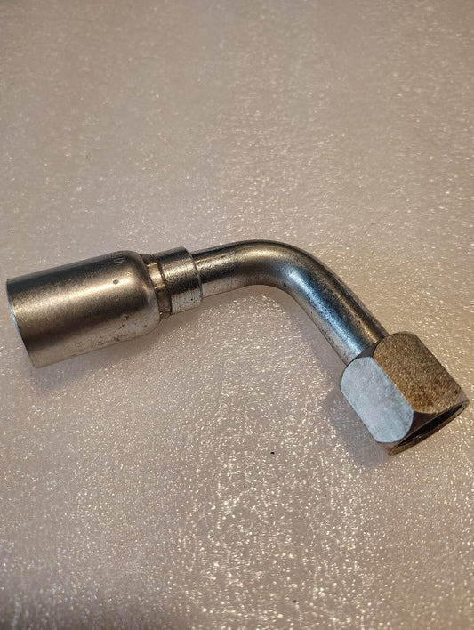 The 08U-650 Weatherhead fitting with a 90-degree bend lies on a textured white surface, featuring a shiny metallic finish, hexagonal nut on one end, and cylindrical connector for 100R1 hoses.