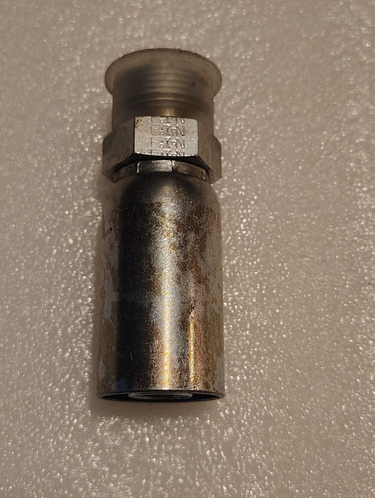 Close-up of a 10U-E70 Weatherhead fitting with a cylindrical, hexagonal nut design. The metallic surface is weathered and textured, set against a white textured background.