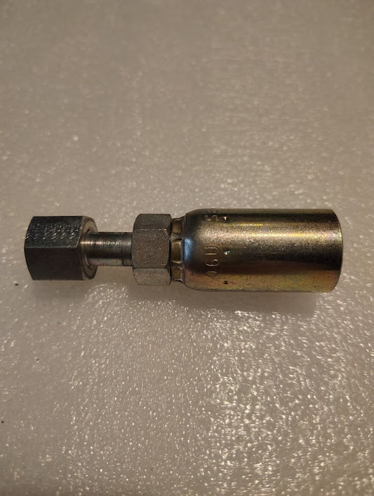 A 06U-S64 Weatherhead 3/8 Hose x 1/4 ORF Female Fitting, featuring a threaded hexagonal end and cylindrical connector, lies on a textured white surface. Tapered towards one end, it appears polished and clean.