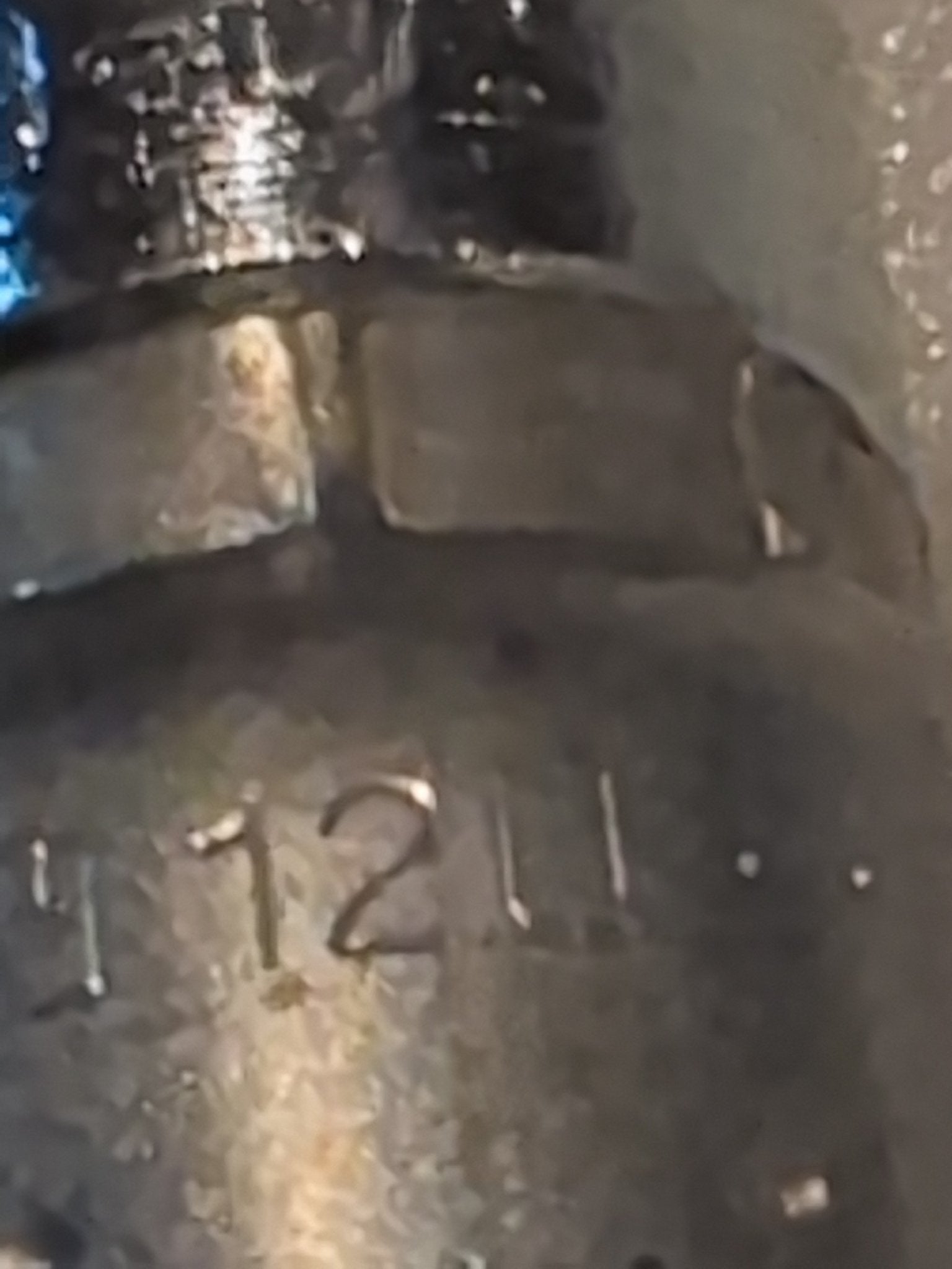 An image shows a close-up of the 12U-L72s metallic surface, engraved with 4.12U. The texture complements 100R series hydraulic hose fittings, revealing its shiny and reflective parts under distinct lighting.