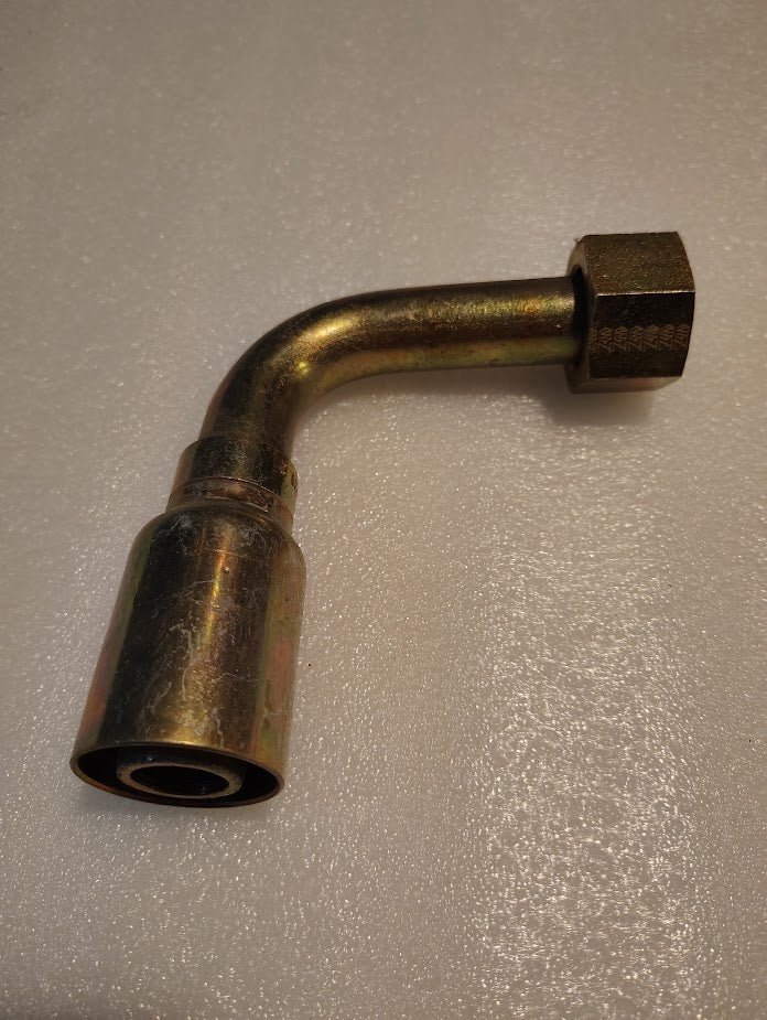 The brass-colored Weatherhead 16U-A76 elbow fitting features a threaded hexagonal nut on one end and a cylindrical opening on the other, designed for hydraulic hose fittings. Compatible with 100R1 hoses, it rests on a light textured surface.