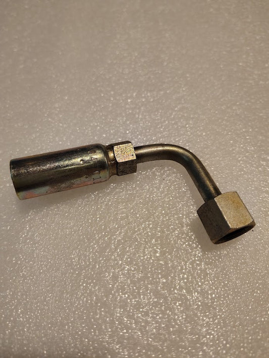 A 04U-A64 Weatherhead fitting with a 1/4 hose and 1/4 ORF female swivel ends lies on a textured, light surface. Its reflective finish and angled bend make it perfect for hydraulic hose systems.