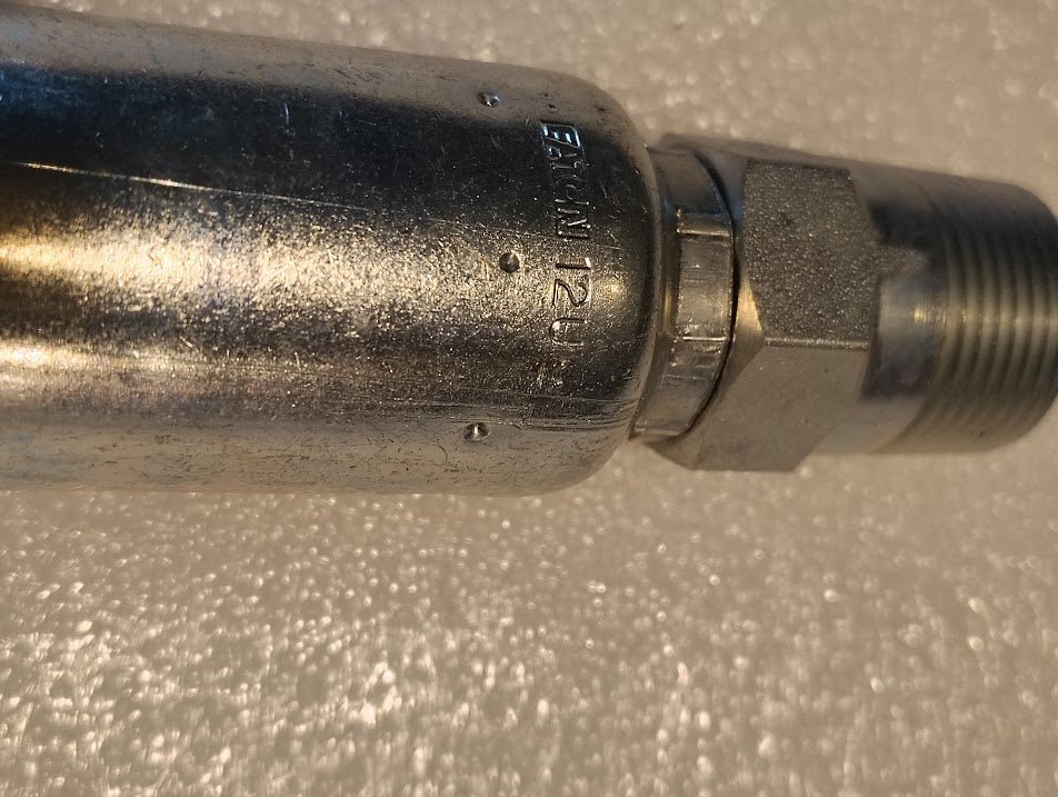 A close-up of the 12U-162 Weatherhead fitting, featuring a shiny finish and visible threading, is marked 12U to ensure compatibility with hoses.