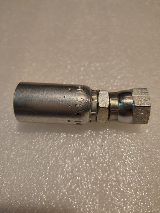 The 06U-10C adapter, a Weatherhead 3/8 hose x M16x1.5 DIN female fitting with threaded connections and engraved markings, sits on a textured surface. It seamlessly integrates into various hydraulic hose applications.