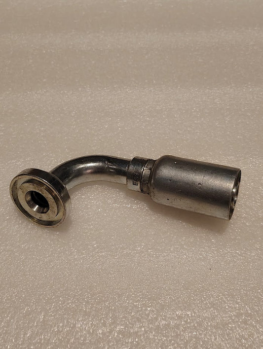 The 12U-G76, a metallic Weatherhead 3/4 Hose x 1 Code 61 Flange Fitting - 90, featuring an L-shaped pipe with flanged end and cylindrical section, lies on a textured light surface, suitable for 100R1 hoses.