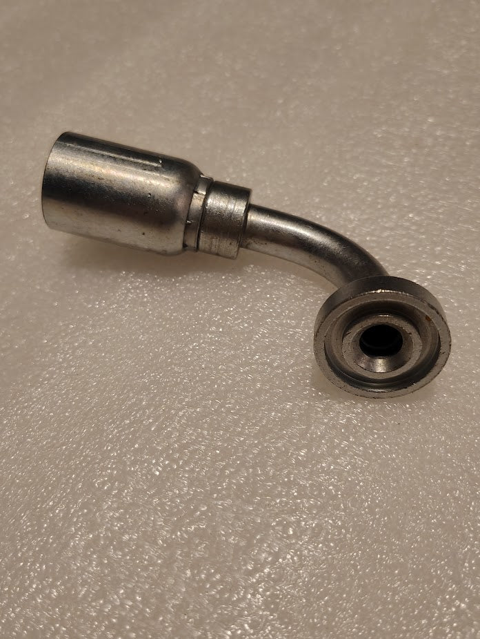 Close-up of a Weatherhead 08U-G71 fitting, featuring a cylindrical connector and curving pipe leading to a circular opening, resembling hydraulic hose fittings, all on a textured white surface.